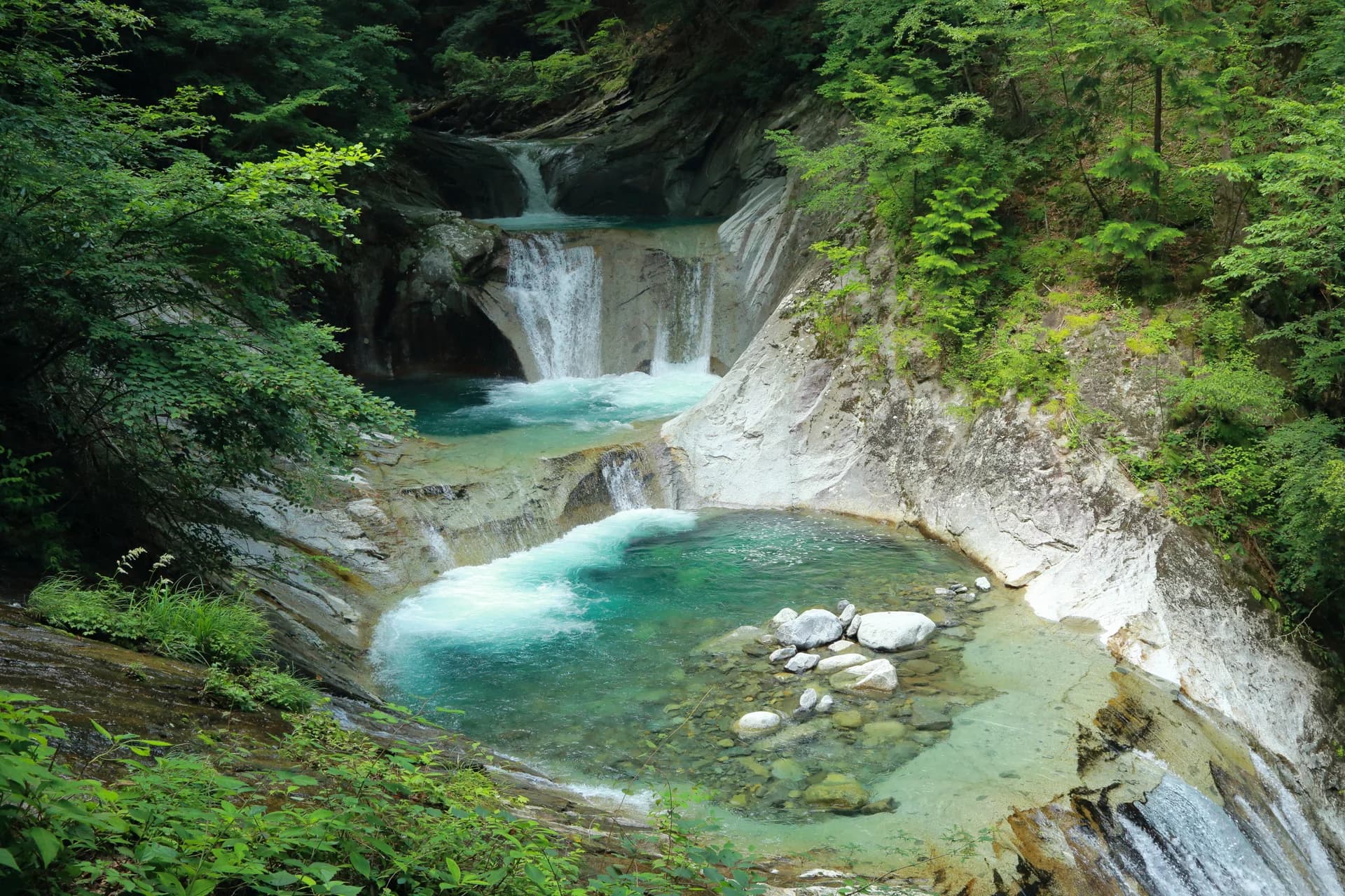 新緑に囲まれた西沢渓谷の滝とエメラルドグリーンの清流